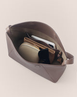 Open handbag with pouches, sunglasses, and a phone inside