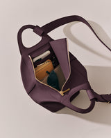 Open handbag with visible contents like wallets and sunglasses