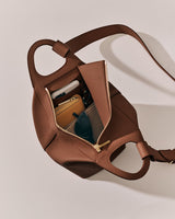 Open bag with phone, sunglasses, wallet, and other items inside.