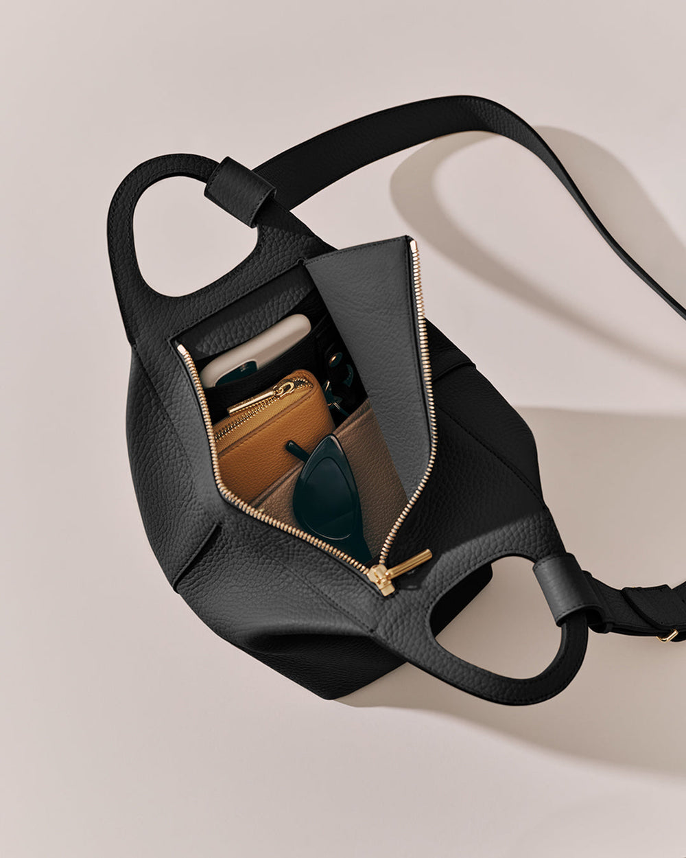 Paloma Bag Open handbag with wallet and sunglasses inside.