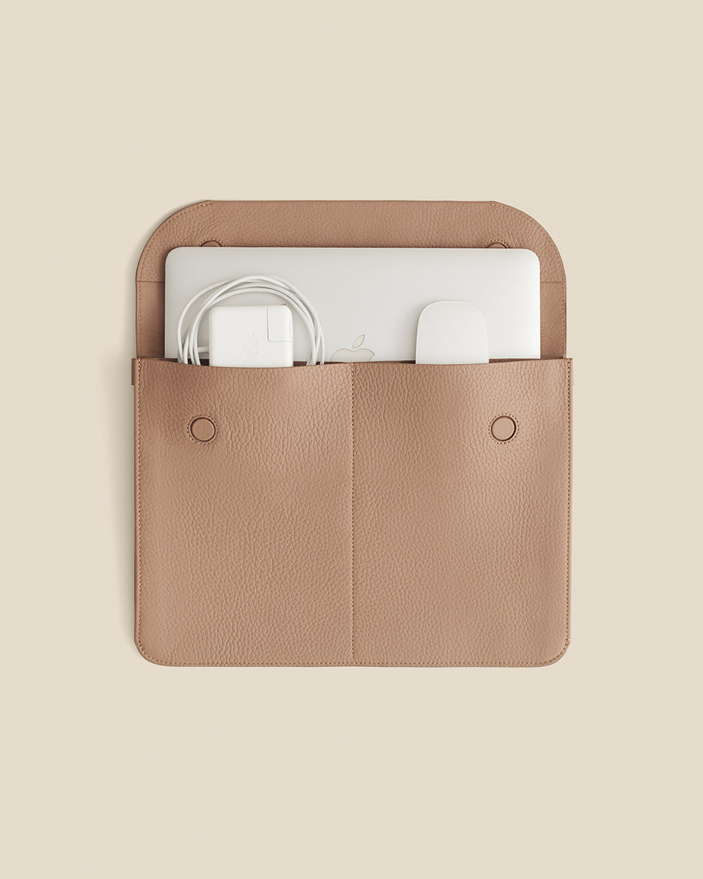 Laptop sleeve with two pockets holding a laptop and cables