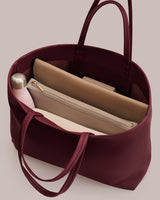 Open tote bag with a bottle, laptop sleeve, and pouch inside.