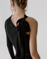 Woman from behind showing top with bow on shoulder.