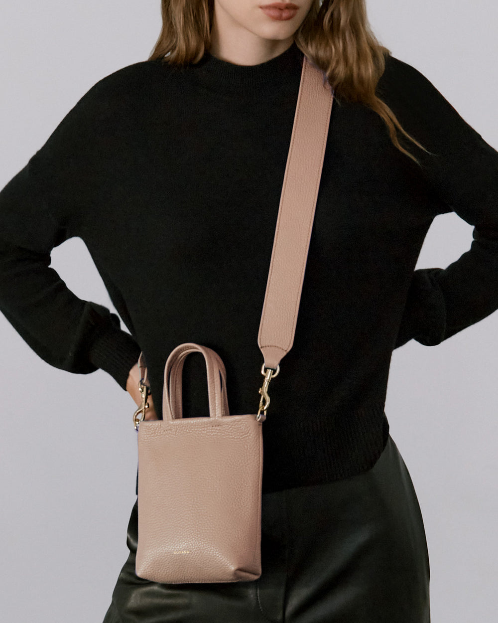 Woman wearing a sweater and carrying a crossbody bag