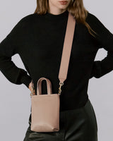 Woman wearing a sweater and carrying a crossbody bag