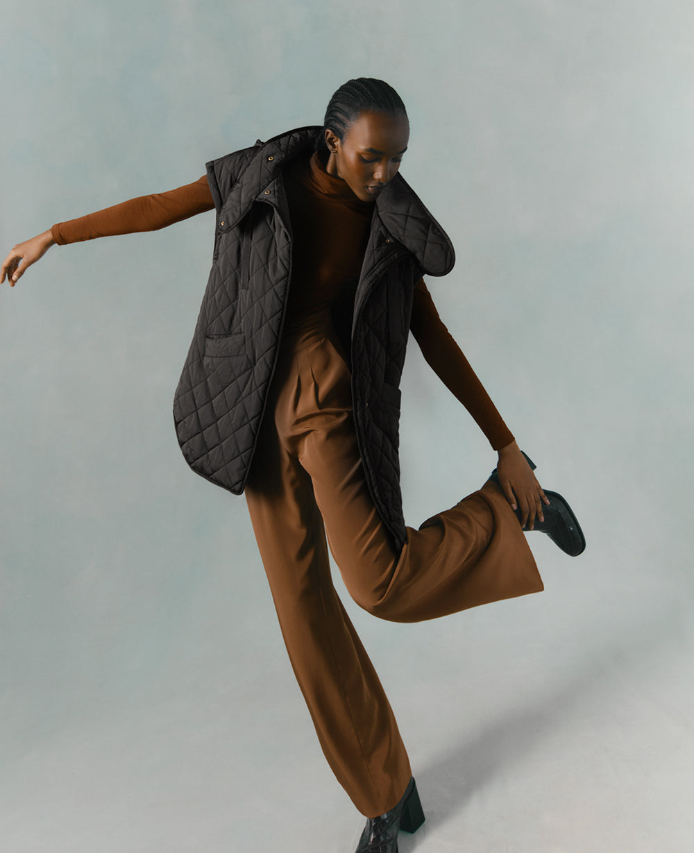 Person in a dynamic dance pose with one leg lifted.