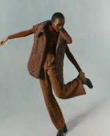 Person in a dynamic pose with one leg lifted, wearing a jacket and pants.