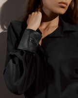 Woman wearing a blouse and leather wrist accessory