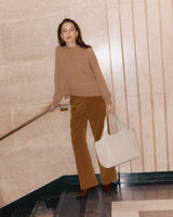 Woman on stairs holding a bag