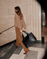 Woman walking up stairs carrying a large bag