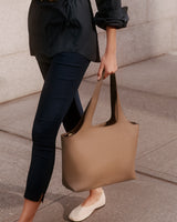 Woman walking while holding a large handbag