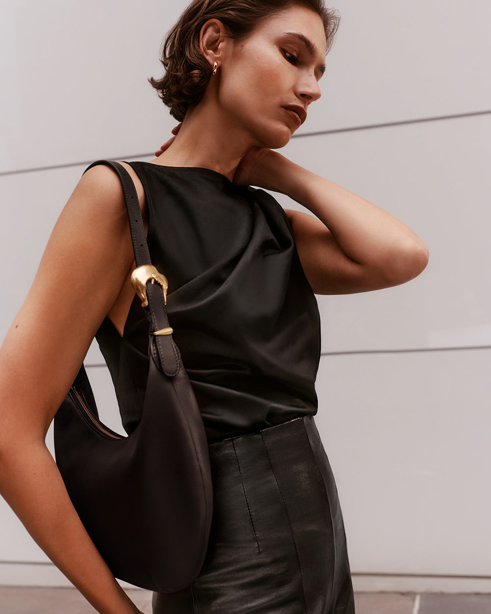 Celestia Shoulder Bag Person posing with arm raised, carrying a shoulder bag