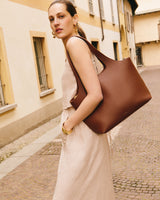 Woman walking with large handbag on cobbled street