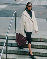 Person in jacket on stairs holding a large bag