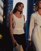 Two women walking in a city street holding bags.