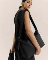 Person carrying a bag over their shoulder and looking over their shoulder