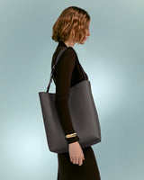 Woman walking with a large shoulder bag.