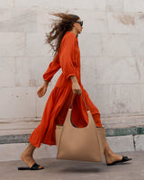 Woman walking briskly while carrying a large bag