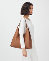 Woman carrying a large tote bag, looking to the side