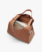Open handbag showing interior with pockets and small items inside.