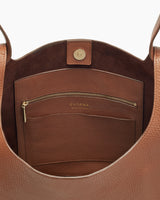 Interior view of an open handbag with a zipper pocket and brand logo.