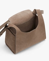 Suede shoulder bag with flap open, showing interior.