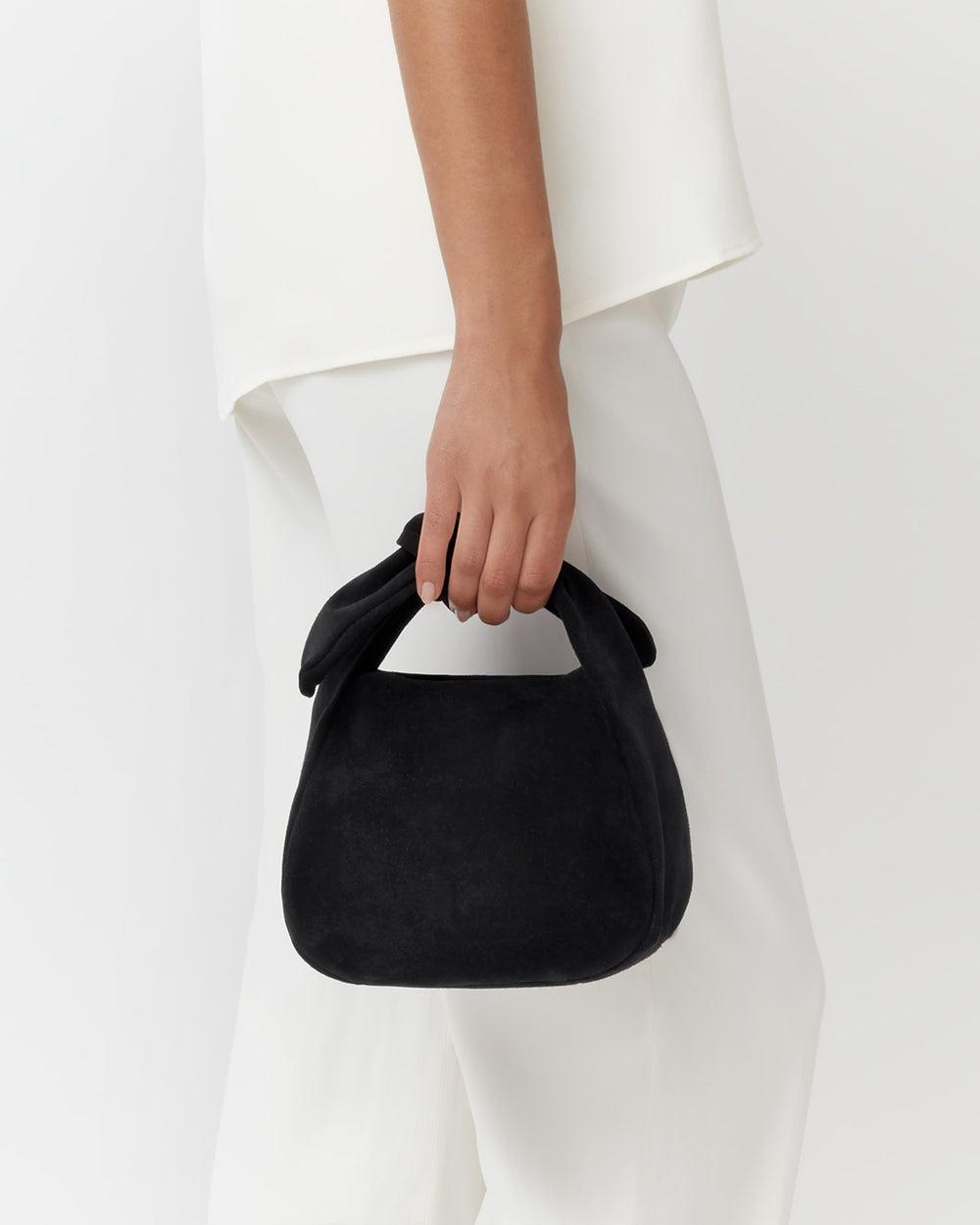 Close-up of a person holding a small handbag.