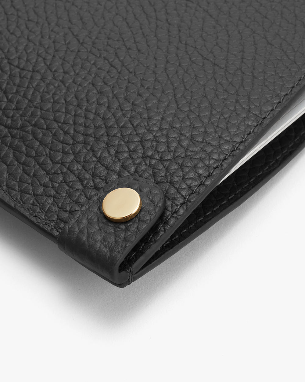 Close-up of a textured clutch with a circular clasp.