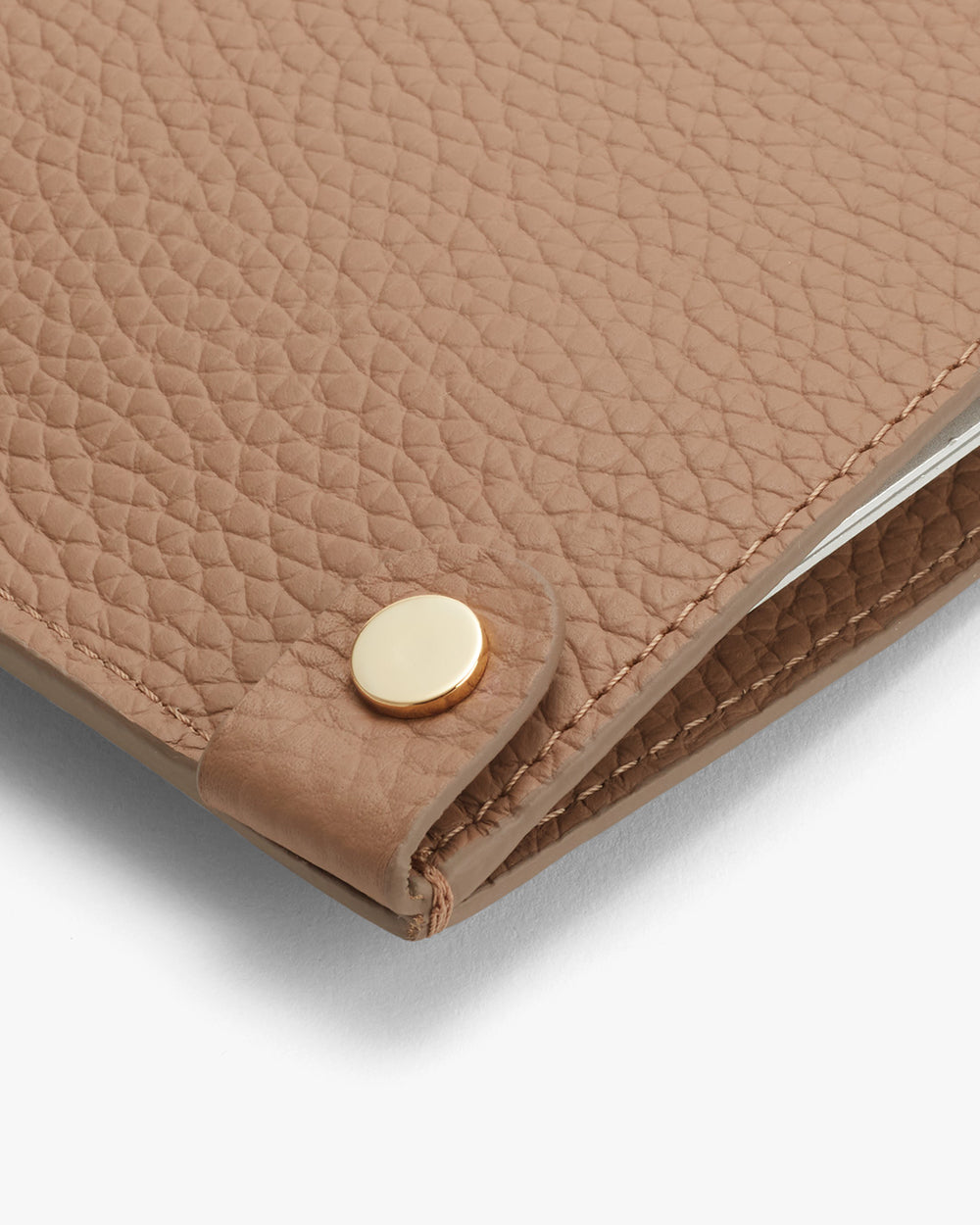 Close-up of a textured wallet with a snap button closure.