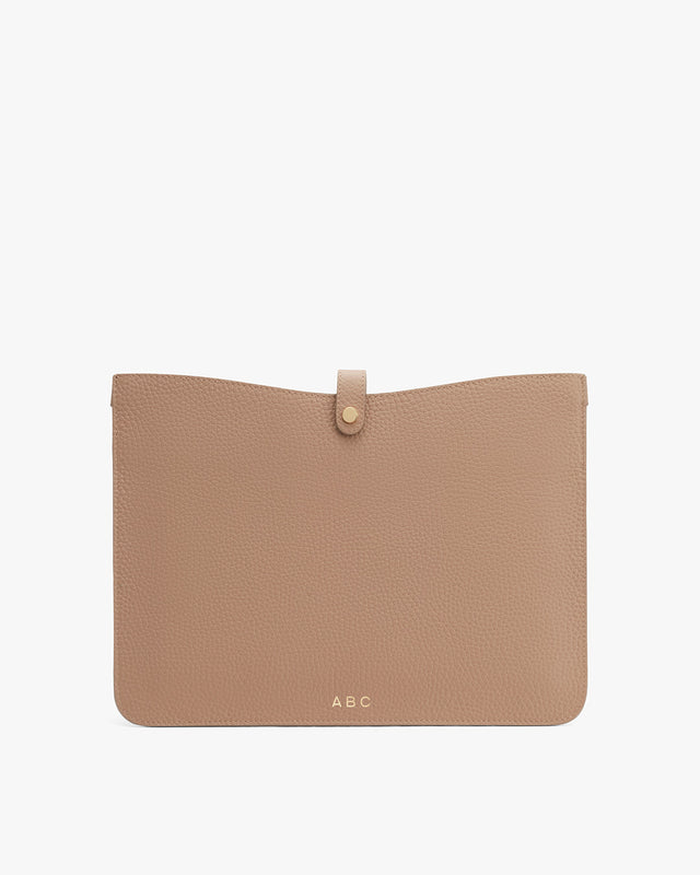 Leather clutch with a front flap and button closure, monogrammed with initials ABC at the bottom center.