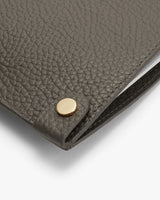 Close-up of a textured wallet with a metallic clasp.