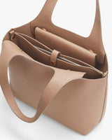 Open handbag with two handles and external pockets.