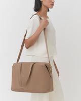 Person holding a travel bag on shoulder