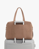 Travel bag on suitcase handle with side pocket facing front