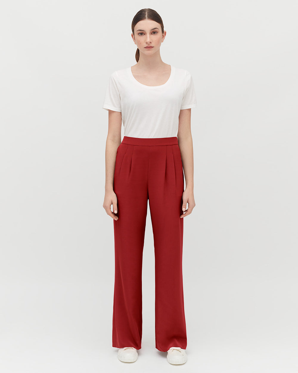 Silk Wide-Leg Pant Woman standing in a plain background wearing a T-shirt and pants.