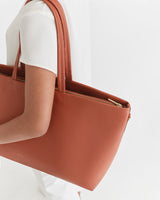 Person holding a handbag over their shoulder