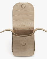 Open croc-embossed leather phone bag with main flap and long handle.