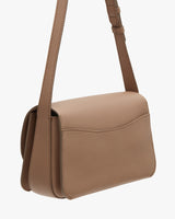 Small shoulder bag with adjustable strap and flap closure.