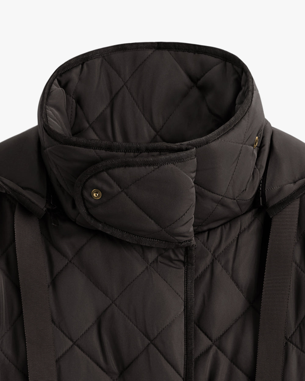Close-up of a quilted jacket with a high collar and button details.
