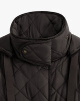 Close-up of a quilted jacket with a high collar and button details.