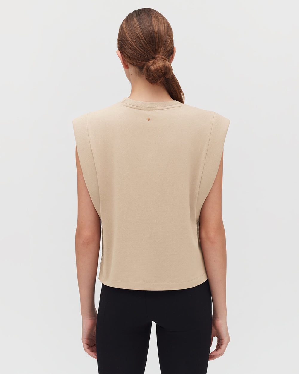 Cropped Tank Person seen from behind wearing a top with a high neckline and open sides.