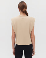 Person seen from behind wearing a top with a high neckline and open sides.