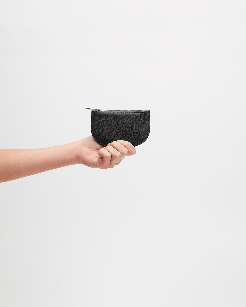 Hand holding a small pouch with a zipper