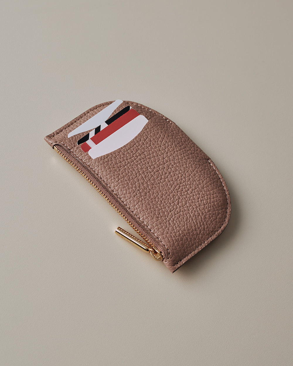 Wallet with zipper partially open showing cards inside.