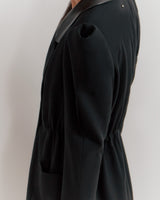 Person wearing a blazer, side view, cropped at shoulders and thighs.