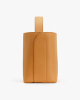 Leather bag standing upright with a loop on top.