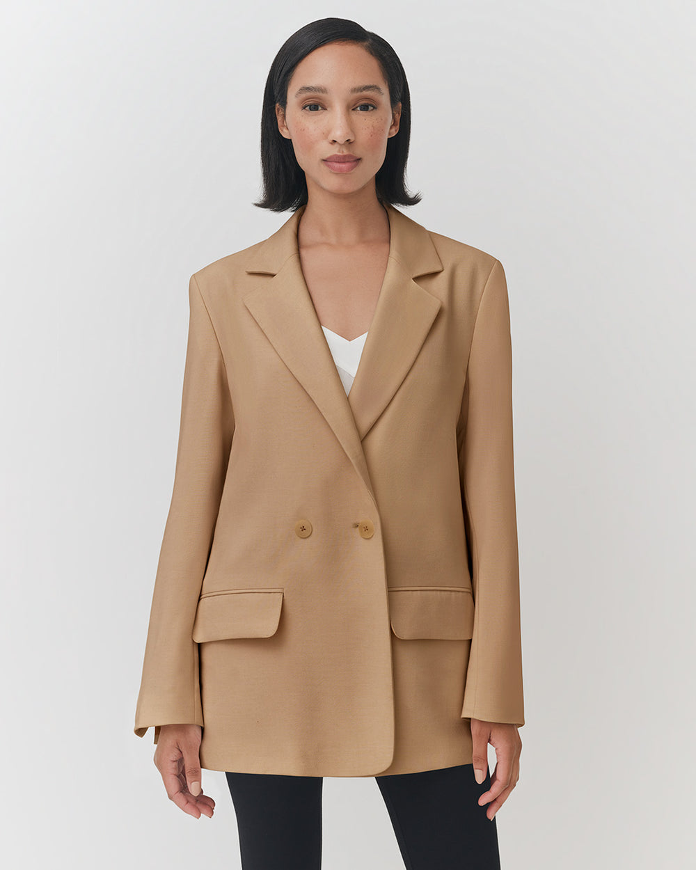Relaxed Blazer Woman standing in a blazer with hands at her sides, looking at the camera.