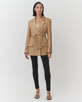 Woman standing in blazer and leggings with sandals