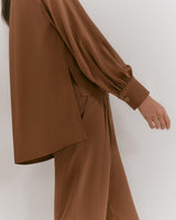 Person wearing a jacket and trousers, partial view.