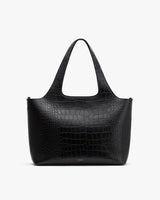 Handbag with textured pattern and a single handle, against a plain background.